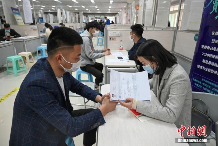 4月14日，招聘者在查看求職者簡歷。<a target='_blank'  data-cke-saved- >中新社</a>記者 王剛 攝